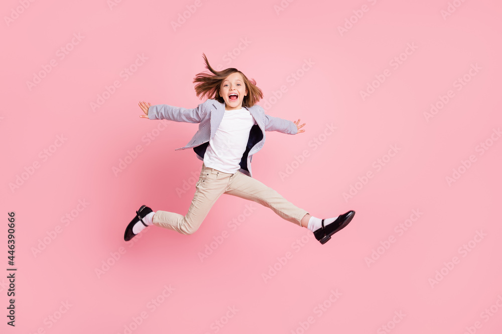 Full body photo of little girl jump wear striped blazer trousers shoes isolated on pastel pink color background Full body photo of little girl jump wear striped blazer trousers shoes isolated on pastel pink color background