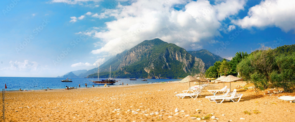 Fototapeta premium Beautiful panoramic view of sea and beach Cirali, Kemer, Antalya, Turkey. Mountains and blue sky with clouds on sunny day.
