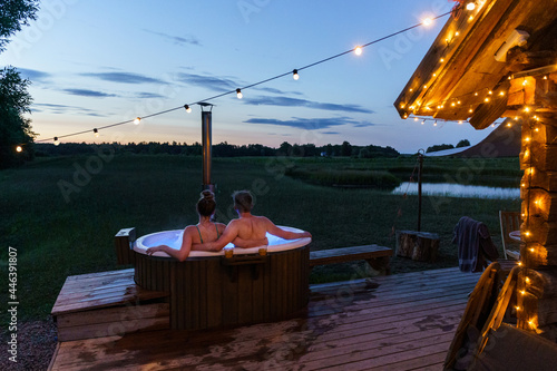 Obraz na płótnie Young couple enjoy outside ofuro japanese hot tub in romantic environment