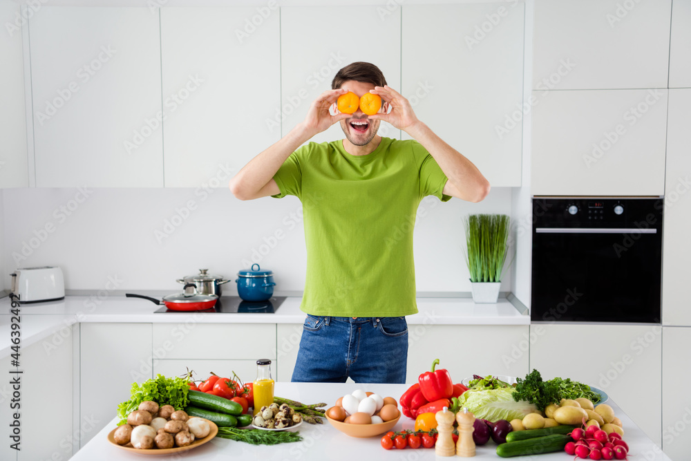 Portrait of attractive cheerful guy cooking food having fun closing eyes with tomato free time at home kitchen indoors Portrait of attractive cheerful guy cooking food having fun closing eyes with tomato free time at home kitchen indoors