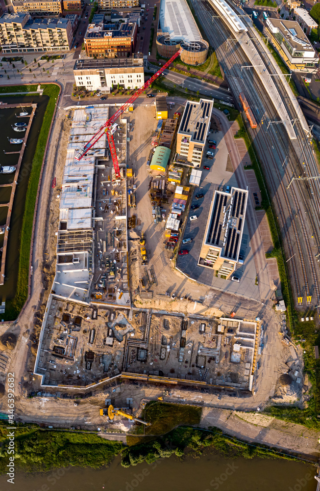 Fototapeta premium Wide panorama of luxury apartment complex construction site at riverbank of river IJssel. Aerial top down blueprint view of the new Kade Zuid project in Noorderhaven residential neighbourhood 