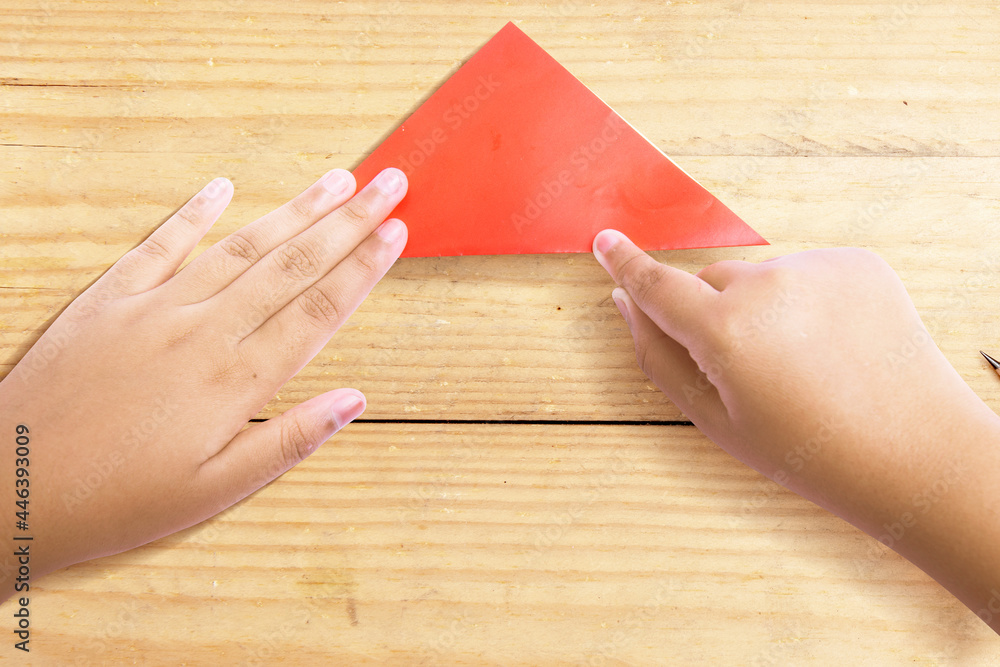Human hand folding a colored paper Human hand folding a colored paper