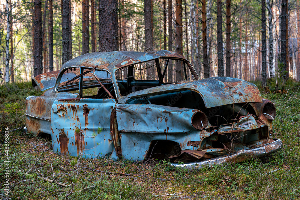 Old retro car abandoned in a forest in Sweden Old retro car abandoned in a forest in Sweden
