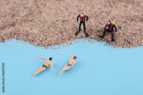 Vászonkép Two divers by the sea watching two swimmers come ashore