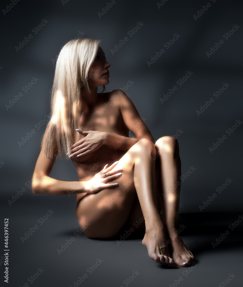 Naklejka premium Art photo, beautiful sexy blonde girl posing nude on a dark background