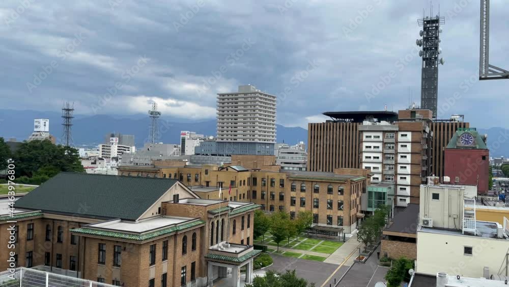 KOFU, YAMANASHI, JAPAN - JUNE 2021 : Cityscape of Kofu city. View of buildings and streets at downtown area near Kofu station. High angle wide view, real time shot. KOFU, YAMANASHI, JAPAN - JUNE 2021 : Cityscape of Kofu city. View of buildings and streets at downtown area near Kofu station. High angle wide view, real time shot.