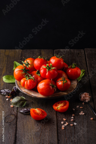 Fresh tomatoes in a plate on a dark background. Harvesting tomatoes. Top view