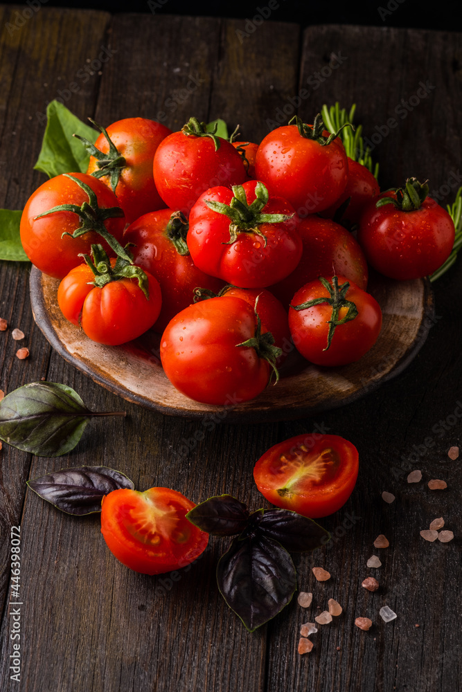 Fresh tomatoes in a plate on a dark background. Harvesting tomatoes. Top view Fresh tomatoes in a plate on a dark background. Harvesting tomatoes. Top view