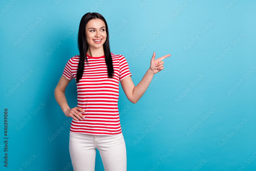 Photo of happy smiling good mood beautiful girl advertisement point finger copyspace isolated on blue color background Photo of happy smiling good mood beautiful girl advertisement point finger copyspace isolated on blue color background