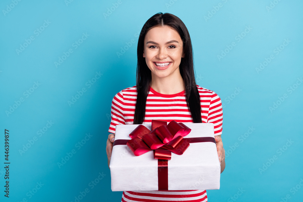 Photo of young girl happy positive smile hold present box birthday party isolated over blue color background Photo of young girl happy positive smile hold present box birthday party isolated over blue color background