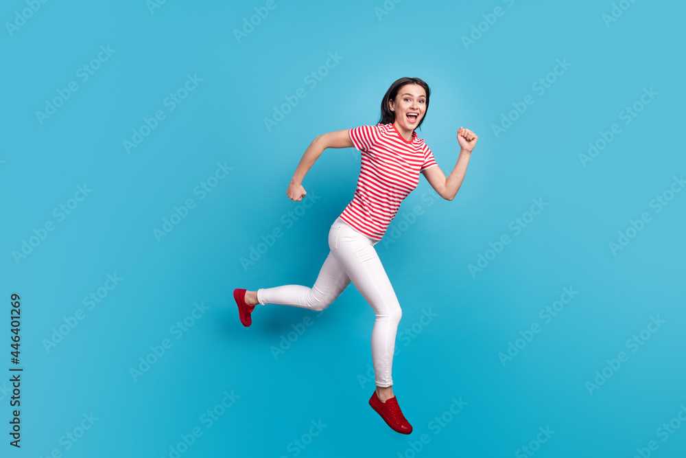 Full size profile side photo of young girl happy positive smile jump go walk run hurry isolated over blue color background