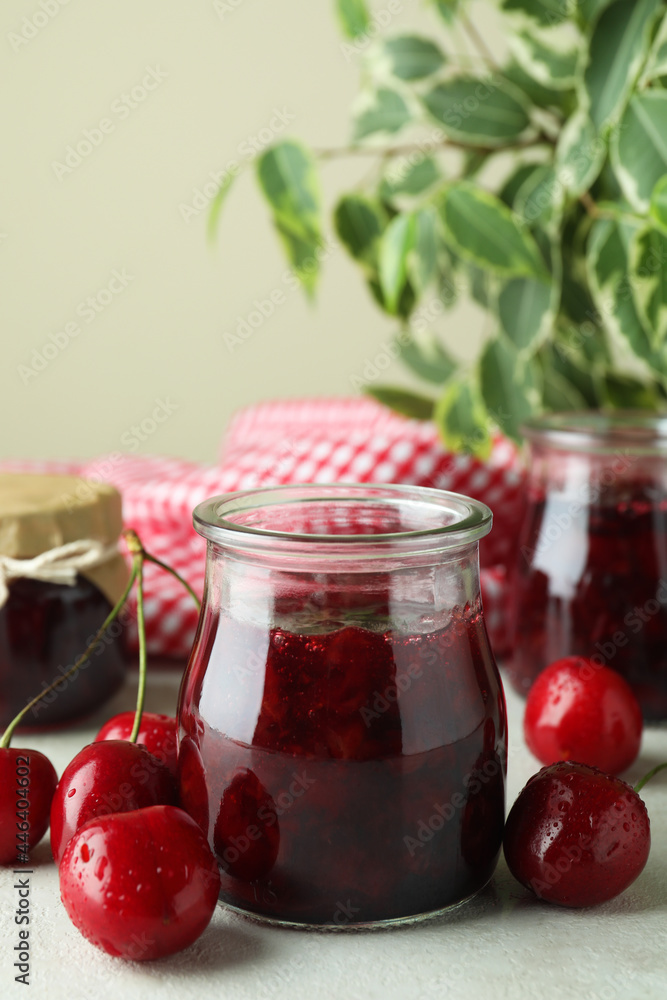 Cherry jam and ingredients on white textured table Cherry jam and ingredients on white textured table