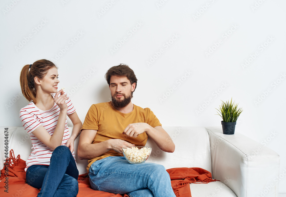 young couple sitting on the couch popcorn watching a movie vacation family