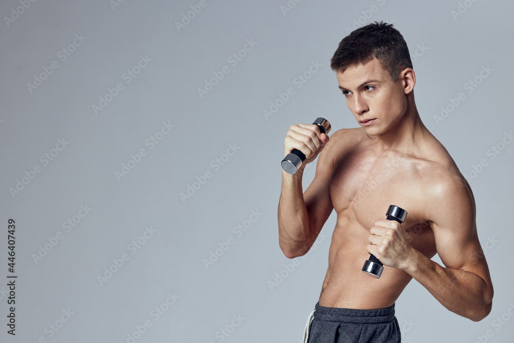athletic man with dumbbells in hand pumped up body exercise isolated background