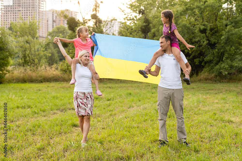 Fototapeta premium Flag Ukraine in hands of little girl in field. Child carries fluttering blue and yellow flag of Ukraine against background field.