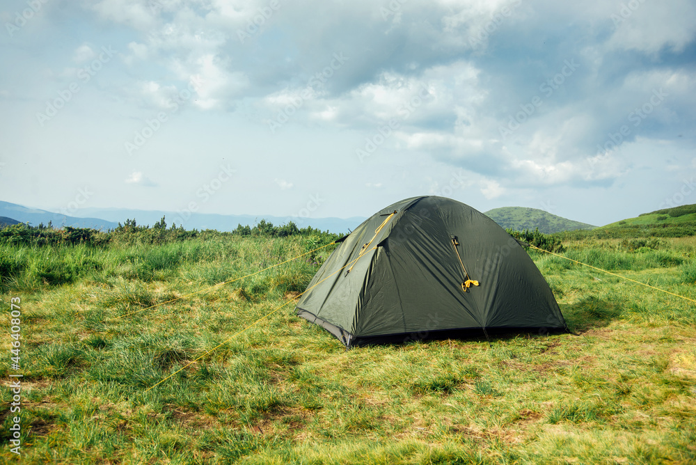 Tourist tent in the mountains view. Domestic tourism, active summer trip. Ecotourism, camping, sports mountain hiking. Copy space Tourist tent in the mountains view. Domestic tourism, active summer trip. Ecotourism, camping, sports mountain hiking. Copy space