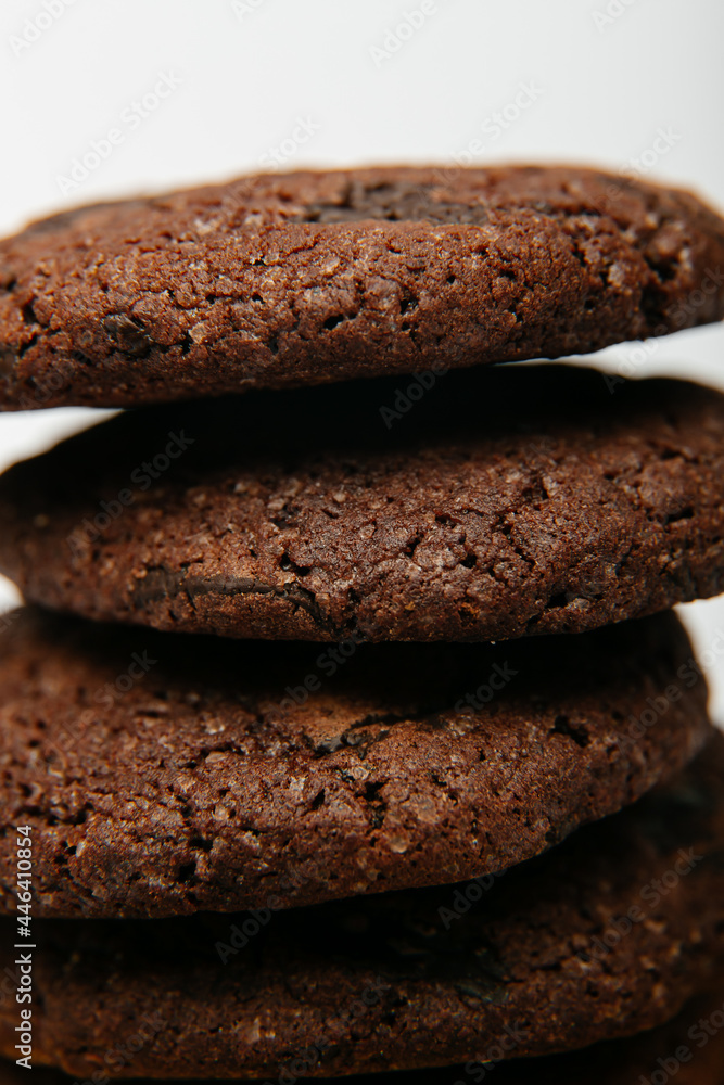 Pile of delicious healthy chocolate cookies on a golden plate and white background Pile of delicious healthy chocolate cookies on a golden plate and white background