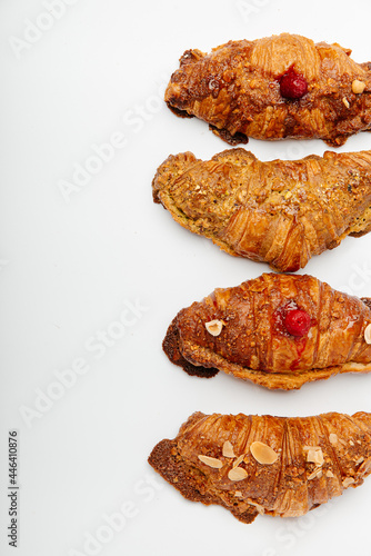 Top view of beautiful handmade delicious croissants decorated with berries and nuts on a white background photo