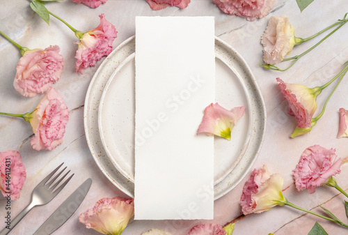 Wedding menu laying on a ceramic plate on a marble table photo