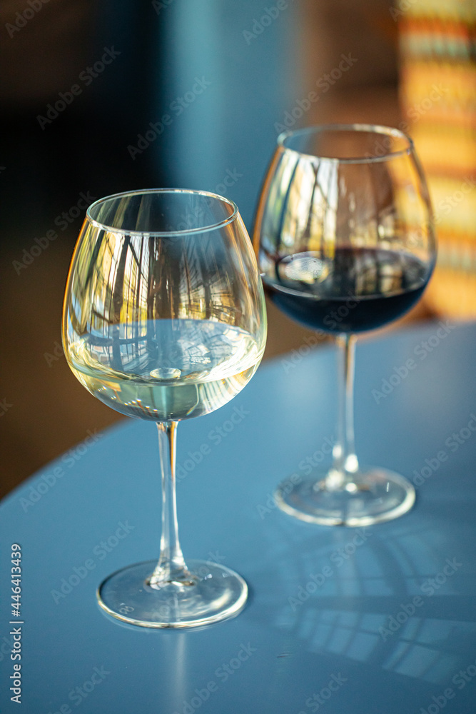 Two glasses of red and white wine on the blue restaurant table Two glasses of red and white wine on the blue restaurant table