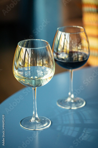 Two glasses of red and white wine on the blue restaurant table