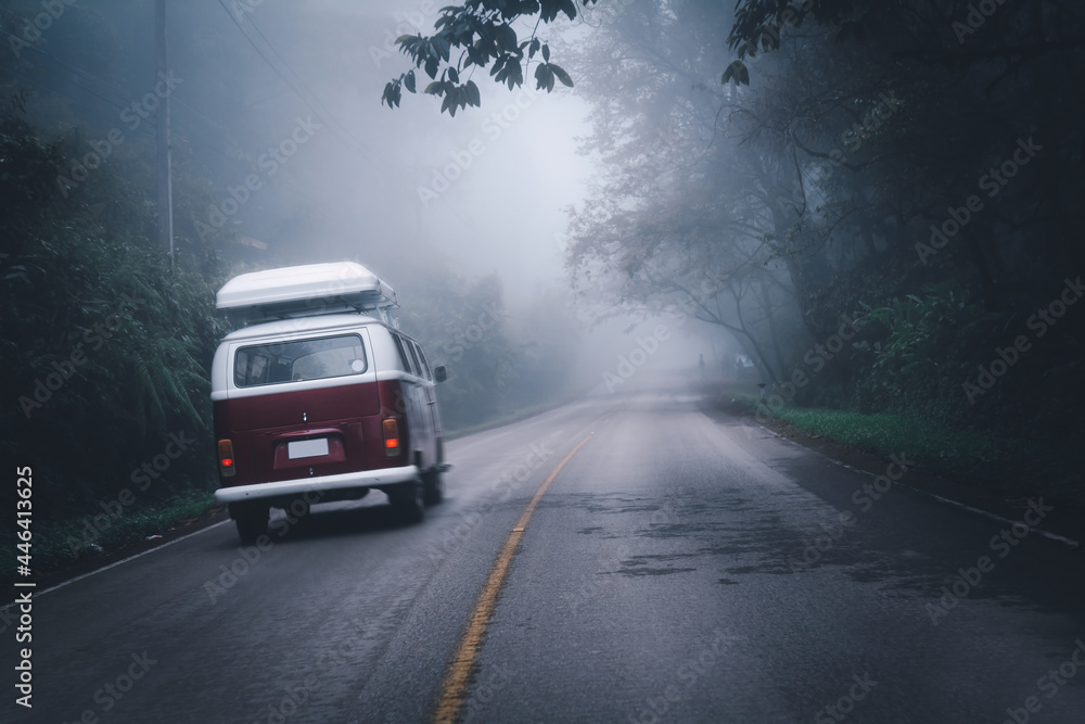 The red van is running to travel on the countryroad in the rainy season, copy space for text.