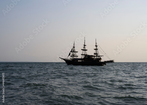 Silhouette of a ship with masts at sunset