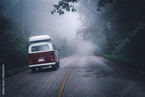 The red van is running to travel on the countryroad in the rainy season, copy space for text.