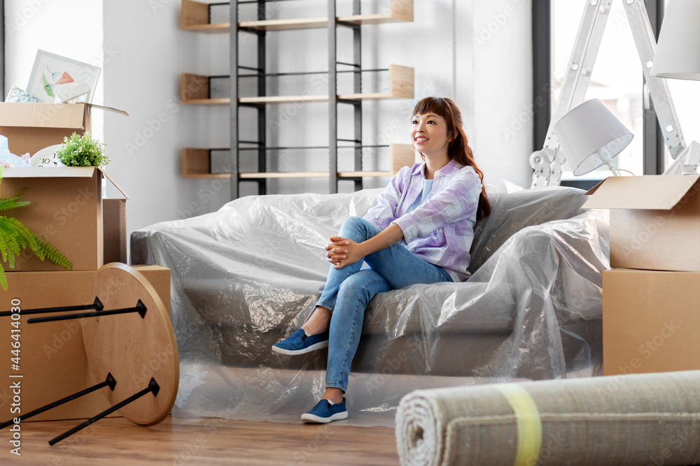 © Syda Productions - people, repair and real estate concept - happy smiling asian woman with stuff moving to new home