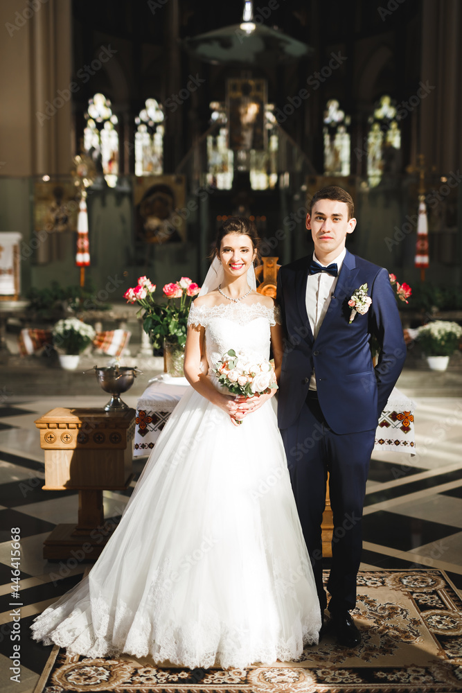 Married couple posing in a church after ceremony