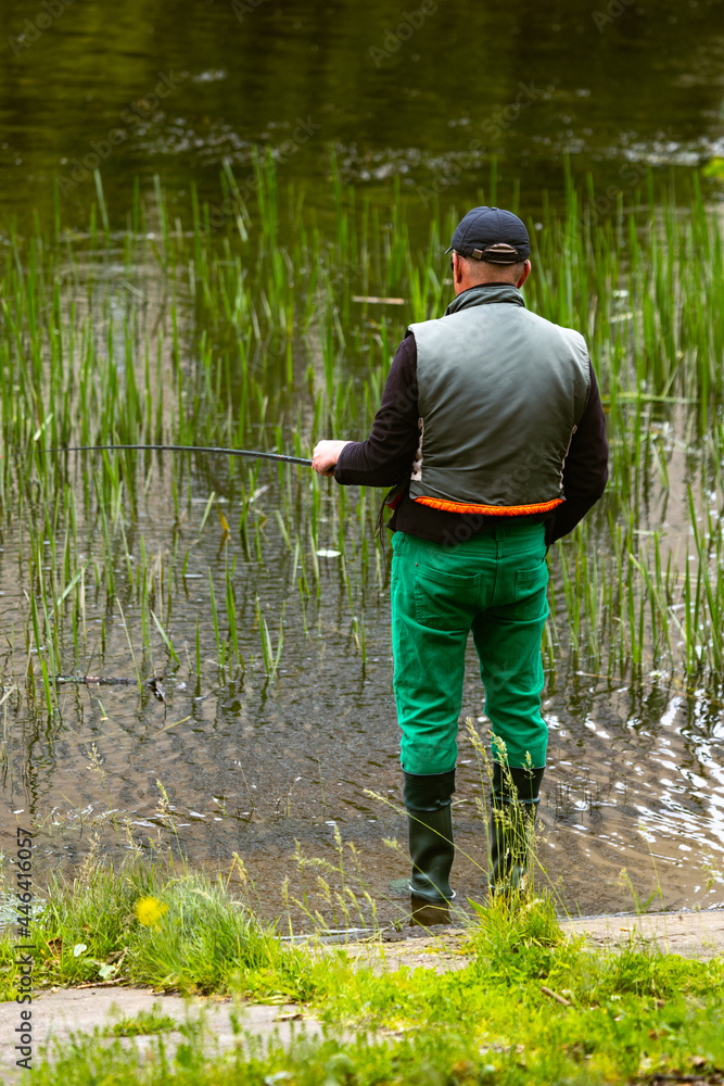 Fishing as a hobby. A man fishing with a fishing rod on the shore of a pond, river or lake, will spend his free time. Fishing as a hobby. A man fishing with a fishing rod on the shore of a pond, river or lake, will spend his free time.