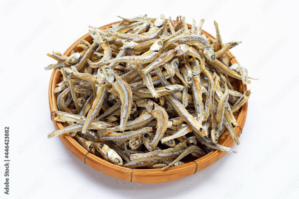 Dried anchovy in bamboo basket on white