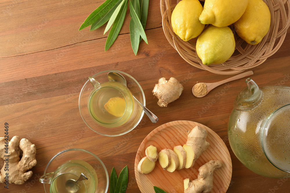Ginger infusion on wooden table with sliced ginger root top Ginger infusion on wooden table with sliced ginger root top