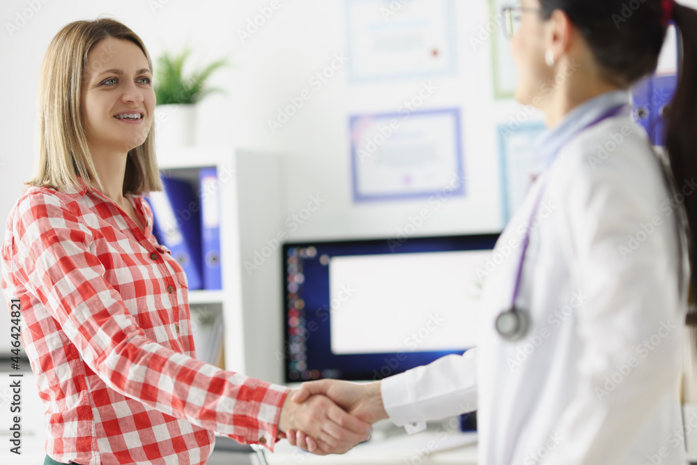 Doctor shakes hands with smiling patient closeup Doctor shakes hands with smiling patient closeup