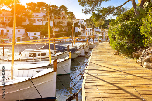 Canvas-taulu White fishing boats moored at a wooden walkway in the beautiful town Cala Figuera, Majorca or Mallorca, sunflare effect