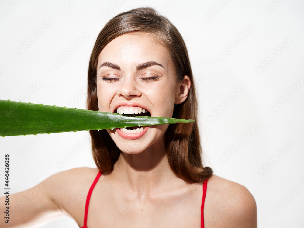 woman with white teeth is biting dining on light background closed eyes model portrait woman with white teeth is biting dining on light background closed eyes model portrait