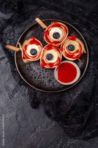 Monster Bloody Eyeballs for Halloween. Crepes roll up with banana and strawberry jam