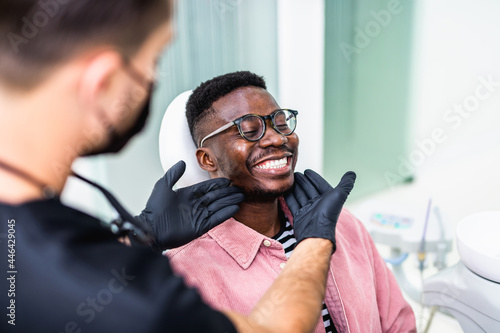 African American young man having a visit at the dentist s. He is sitting on chair at dentist office in dental clinic.