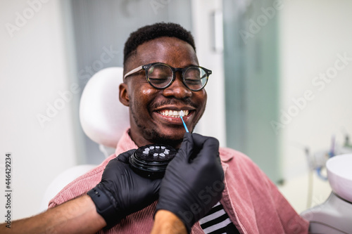 African American man having dental treatment with lumineers at dentist's office. photo