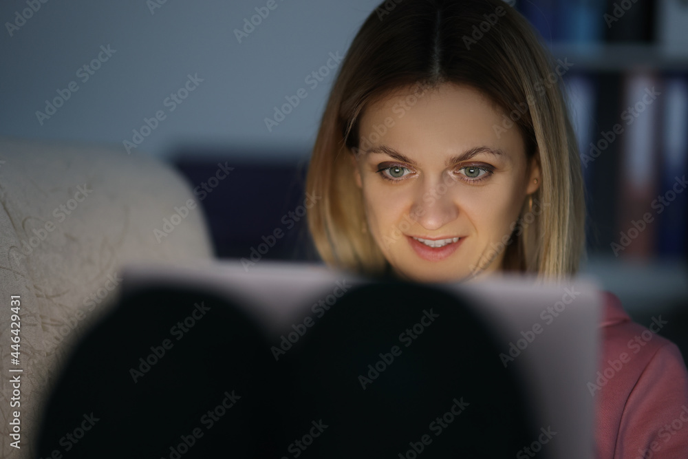 Portrait of woman in dark looks at screen of tablet Portrait of woman in dark looks at screen of tablet