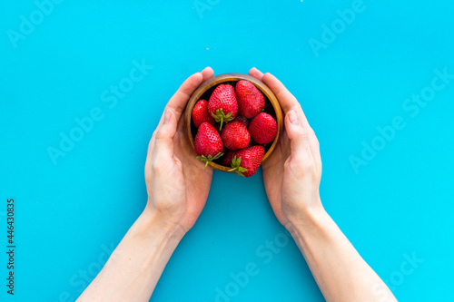 Fototapeta Naklejka Na Ścianę i Meble -  Juicy strawberry with leaves in bowl, top view