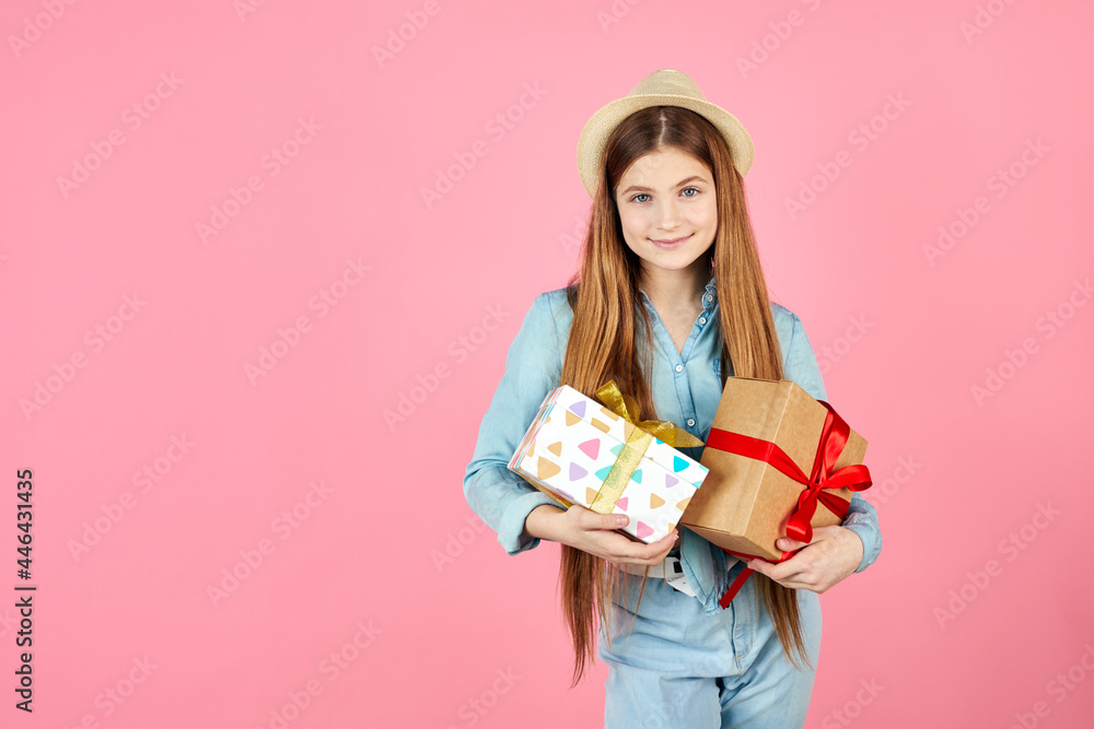 Smiling girl in jeans clothes and straw hat isolated on pink background. Valentine's Day, Women's Day, birthday concept. Hold present box with gift ribbon bow.
