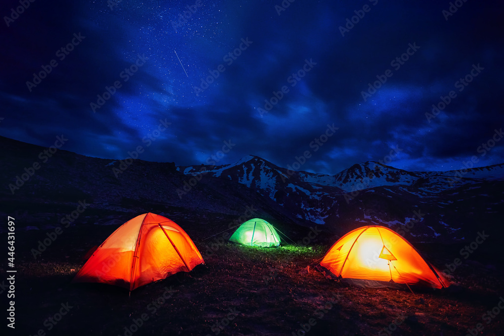 Glowing tents camping in the Night Mountains