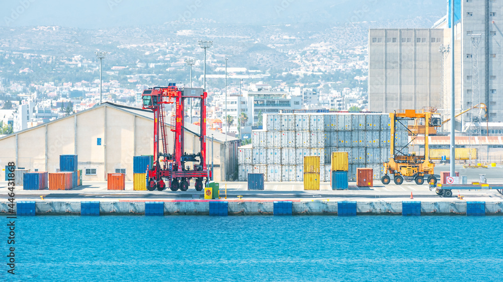 Obraz premium Two shipping container carriers in front of warehouse at port cargo terminal