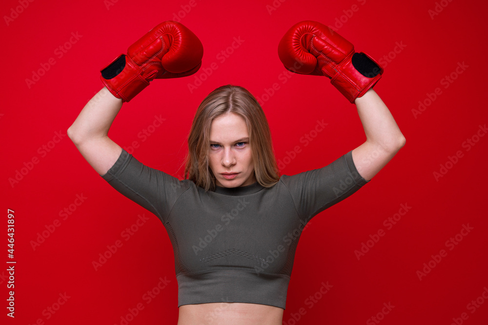 Sporty young woman in red boxing gloves is fooling around Sporty young woman in red boxing gloves is fooling around
