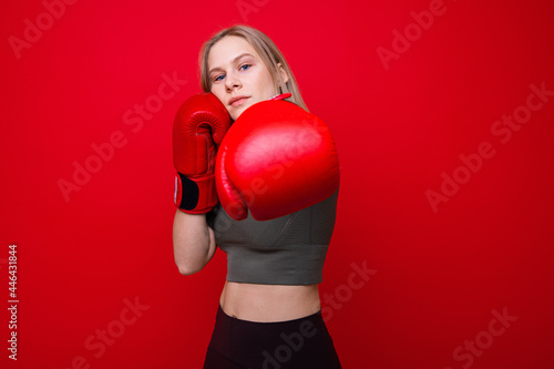 Sporty young woman in red boxing gloves practicing punches © makedonski2015