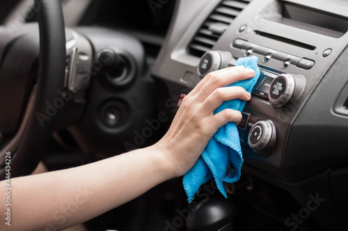 The hand wipes the interior of the car with a rag. Close up