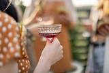Young people having fun, celebrating with alcohol outdoors. Woman holding wine glass, close-up