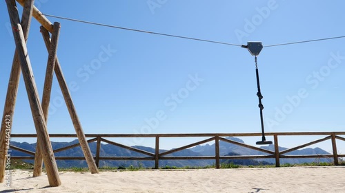 Zip wire with empty seat in park nature, cable aerial ropeslide runway. Mountains rest area place in Spain Alicante region. Costa Blanca holiday. photo