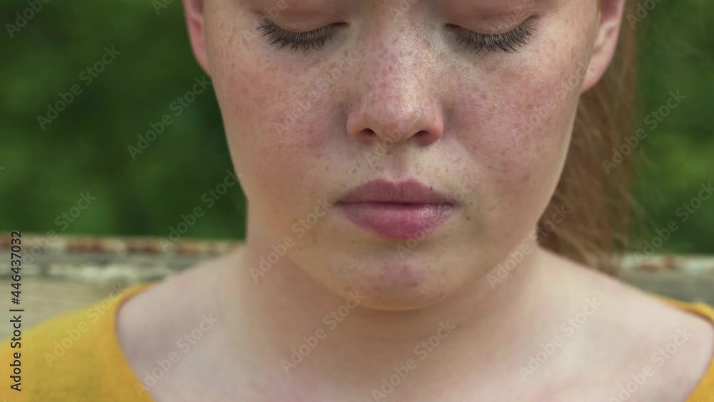 Close up portrait of beautiful redhead girl with freckles reading messages on smartphone Close up portrait of beautiful redhead girl with freckles reading messages on smartphone